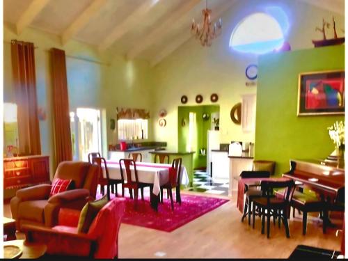 a living room with a table and chairs at Bella Rosa Cottage in Clarens