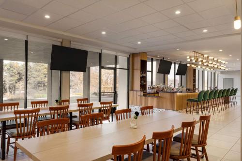 a restaurant with tables and chairs and a bar at Wyndham Garden Atlanta Airport in Atlanta