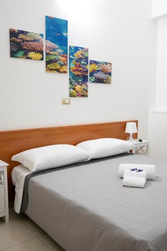 a bedroom with a bed with four paintings on the wall at B&B L' Oasi in Chiatona