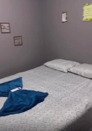 Un dormitorio con una cama con una camisa azul. en Casa temporada Tarumã 02, en Tangará da Serra