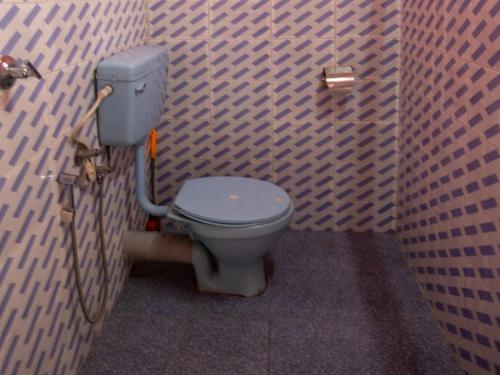 a bathroom with a toilet in a brick wall at Peshok Subba Homestay By StayApart in Darjeeling