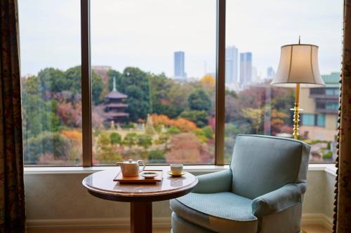 a room with a chair and a table and a window at Hotel Chinzanso Tokyo in Tokyo