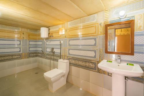 a bathroom with a toilet and a sink at The Saffron Desert Camp, Jaisalmer in Jaisalmer