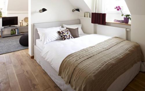 a bedroom with a white bed and a television at KönigsSCHLAF No5 - Barrierefrei, chic & gemütlich in der Altstadt in Konstanz