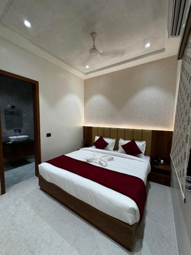 a bedroom with a large bed with red and white pillows at THE TAJ PEARL HOTEL in Agra