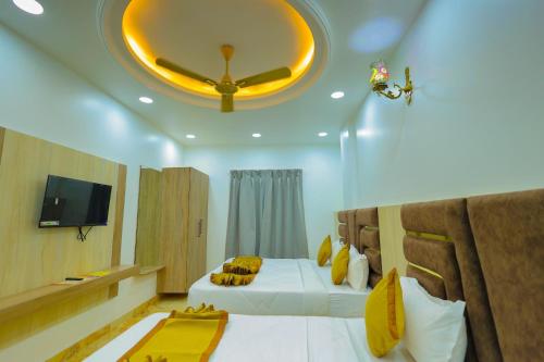 a bedroom with two beds and a ceiling fan at Maa Kela Devi Shanti Atithi Bhawan in Vrindāvan