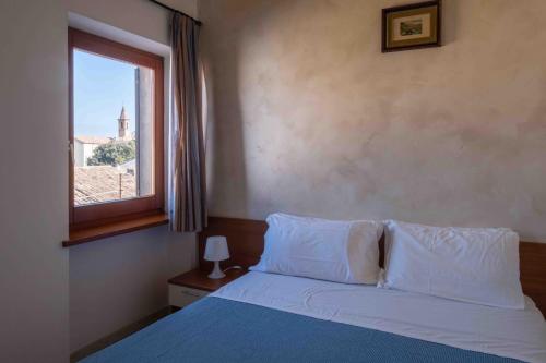 Un dormitorio con una cama y una ventana con vistas. en Il Castagno, en Orciano di Pesaro