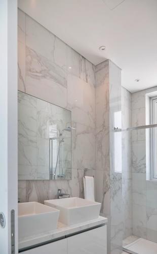 a white bathroom with a sink and a mirror at Sea Pearl Seaview Villa - Oriana in Ayia Napa