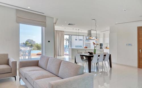 a living room and kitchen with a couch and a table at Sea Pearl Seaview Villa - Oriana in Ayia Napa