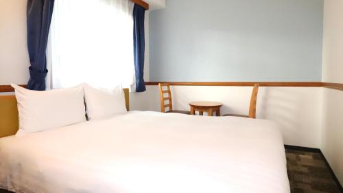 a bedroom with a white bed and a window at Toyoko Inn Tokyo Monzen-nakacho Eitaibashi in Tokyo