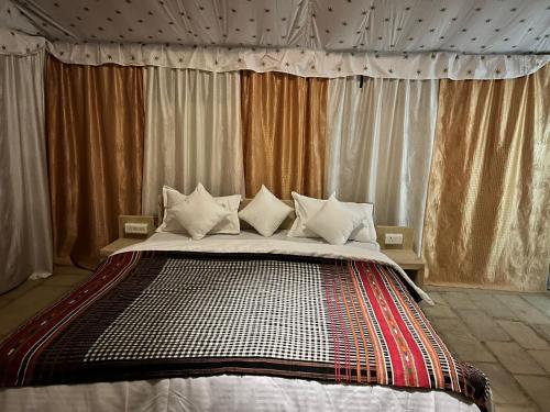 a bedroom with a large bed with curtains at Taj heritage camp& resort in Jaisalmer