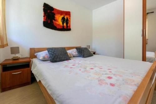 a bedroom with a large bed with a painting on the wall at Apartment Jurja in Ledenice