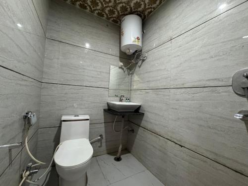 a bathroom with a toilet and a sink at Hotel Vrinda Sarovar in Mathura