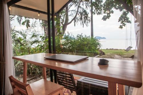 a table with a laptop sitting on top of a window at Beach front cottage in Haad Pleayleam