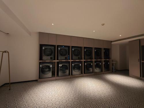 成都市にあるThe Panda Artisan, Taikoo Li Xilia Hotelの洗濯機がたくさんあるランドリールーム