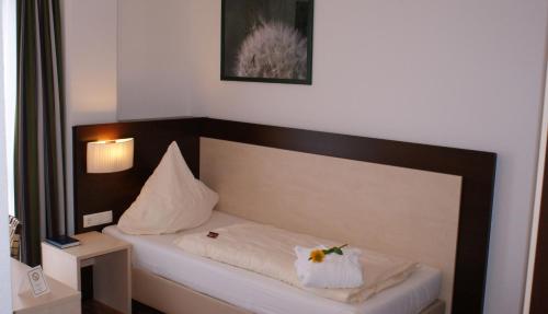a bed in a room with a flower on it at Hotel im Kornspeicher in Marburg an der Lahn