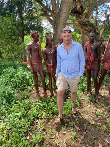 a man standing in front of a group of people at Maasai village home stay in Sekenani