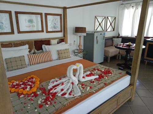 un dormitorio con dos cisnes hechos de flores en una cama en Le Kekeri Villas Collection, en Mataram