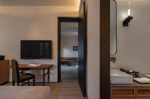Una habitación de hotel con una cama, un escritorio y un televisor. en Sunset Garden Hotel, en Gulang Yu