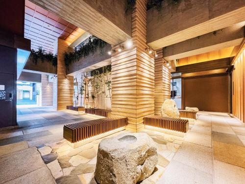 a lobby of a building with a bench and a rock at HOTEL HILLARYS Akasaka in Tokyo