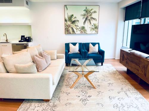 sala de estar con sofá blanco y silla azul en Ocean View Spa Apartment in Q Tower, en Gold Coast