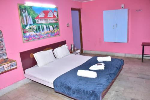 a pink room with a bed with towels on it at Mookambigai Residency in Kodaikānāl