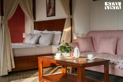 a living room with a couch and a table at StayVista at The Harbhson House with Pool, Jacuzzi, Sauna room, Woodfire Pizza, Projector in Bidauli