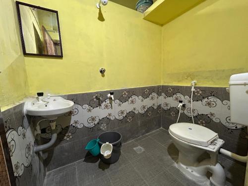 ein Badezimmer mit Toilette und Waschbecken in der Unterkunft The Kaya Pilgrim's Cottage Srirangam in Tiruchchirāppalli