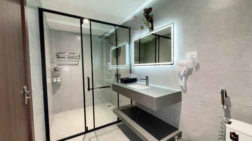 Un baño con lavabo y ducha de cristal. en Sunrise Mountain View Resort, en Vang Vieng