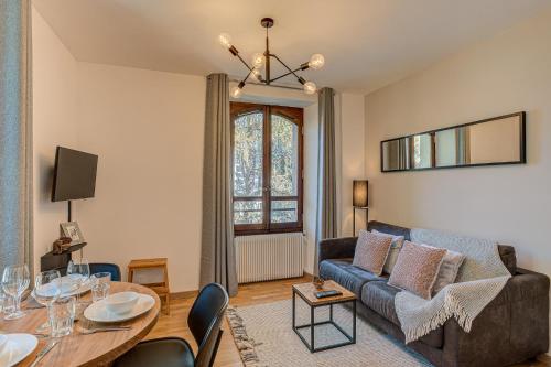 una sala de estar con un sofá y una mesa en Apartment La Roseraie - Alpes Travel - Central Chamonix (sleeps 2-3), en Chamonix-Mont-Blanc