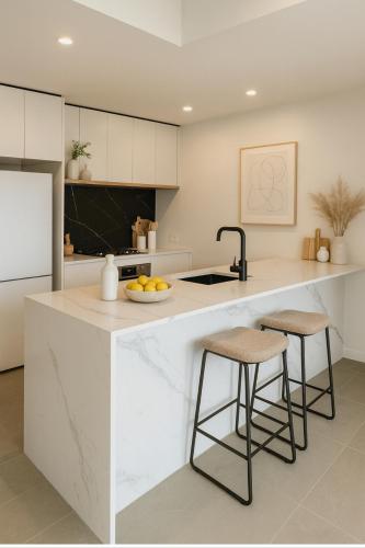 a kitchen with a white counter and stools at Luxury 2BR Stay near Olympic Park Parramatta FREE Parking in Sydney