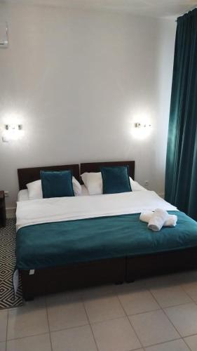 a large bed with blue pillows in a room at Perła Dalików in Dalików