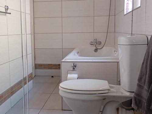 une salle de bain avec toilettes et baignoire dans l'établissement Sunset Cottage - Own Water - Own Electricity, à Pretoria