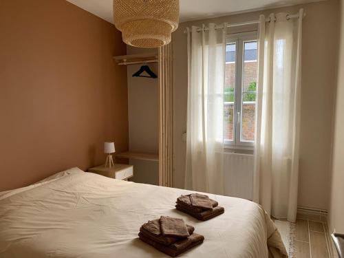 a bedroom with a bed with two towels on it at Bel appartement en centre-ville de Cambrai in Cambrai