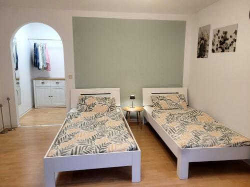 Un dormitorio con dos camas y un espejo. en Work & Stay Holidayflat, en Kusterdingen