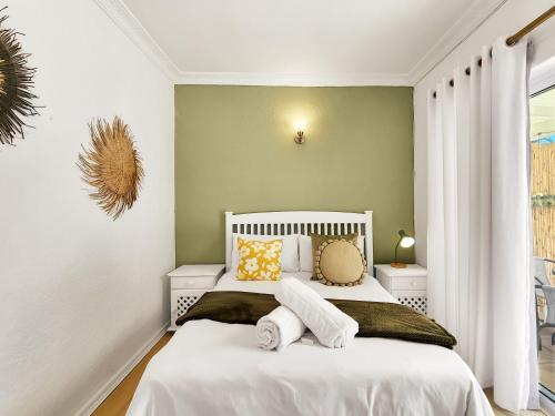 a bedroom with a white bed with two pillows at 70 on Brander in Cape Town