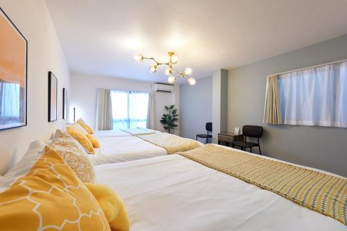 a bedroom with two beds and a chandelier at 新大阪10分 - 1stop Umeda, Shin-Osaka 10m, USJ 30m, MAX6 - XS46 in Osaka