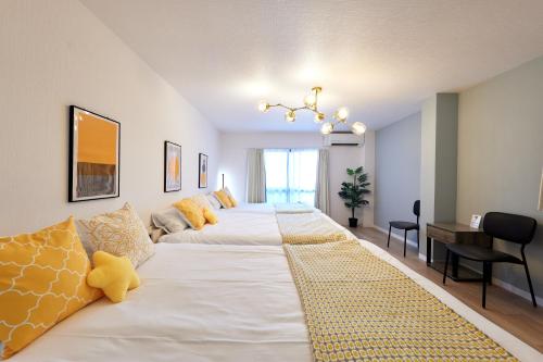a large white bed with yellow pillows in a room at 新大阪10分 - 1stop Umeda, Shin-Osaka 10m, USJ 30m, MAX6 - XS46 in Osaka