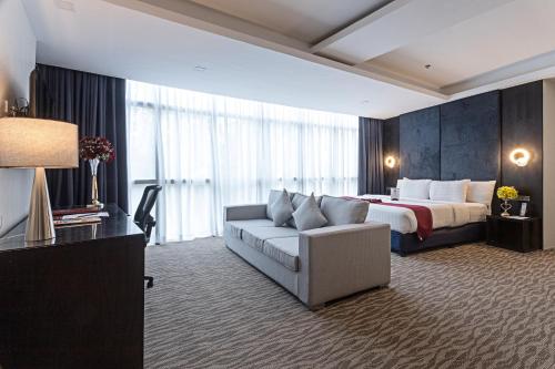 a large hotel room with a bed and a couch at Sarrosa International Hotel and Residential Suites in Cebu City