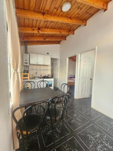 a dining room with a table and chairs and a kitchen at El Quisco cabaña con estacionamiento sector tranquilo in El Quisco