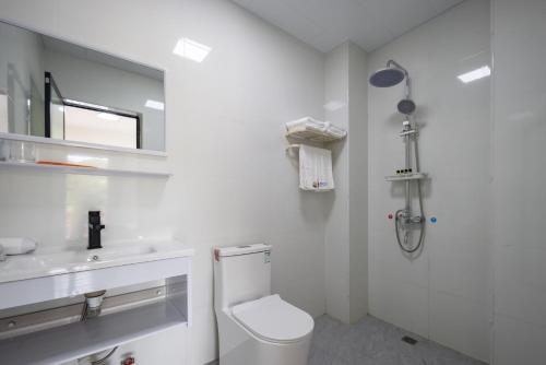 a white bathroom with a toilet and a sink at Haishu Yuntian 