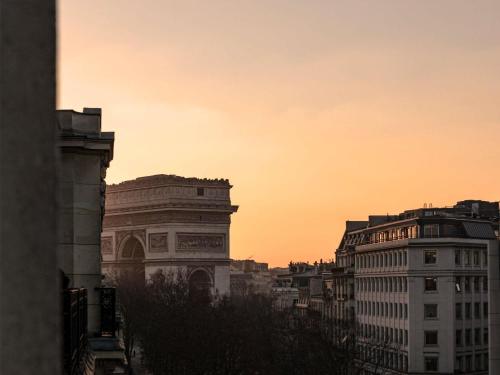 eine Skyline mit Gebäuden und einem Sonnenuntergang in der Unterkunft Hôtel Le Royal Monceau Raffles Paris in Paris