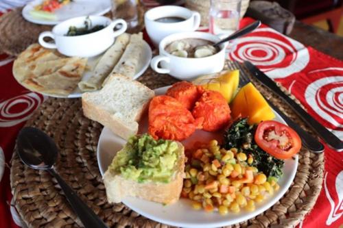 a plate of food with vegetables and bread on a table at Central Beautiful & peaceful Private bedroom AC, Very fast WiFi 1 in Dar es Salaam