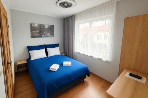 a bedroom with a blue bed and a window at JoValiMarAnt in Mikołajki
