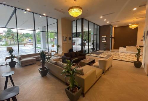 a living room with couches and chairs and windows at GYDEN STAYCATION #Straits Suites & Residences in Johor Bahru