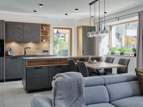 a kitchen and dining room with a couch and a table at Lodge am Wetterstein in Ehrwald