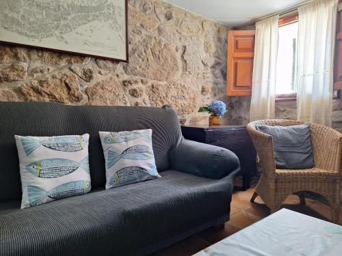 a living room with a couch and a stone wall at San Roque 52 in Combarro