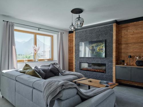 a living room with a couch and a fireplace at Lodge am Wetterstein in Ehrwald