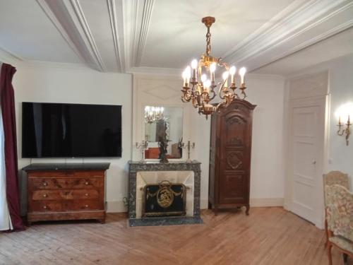 a living room with a television and a fireplace at Le Royal in Bayeux