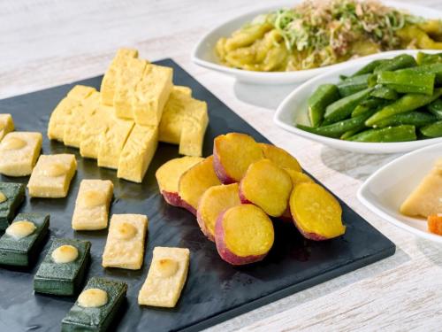 Un plato de comida con queso y verduras en una mesa. en RIHGA Royal Hotel Kyoto, en Kioto